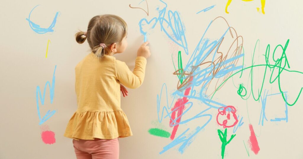 壁に落書きをする子どもの写真